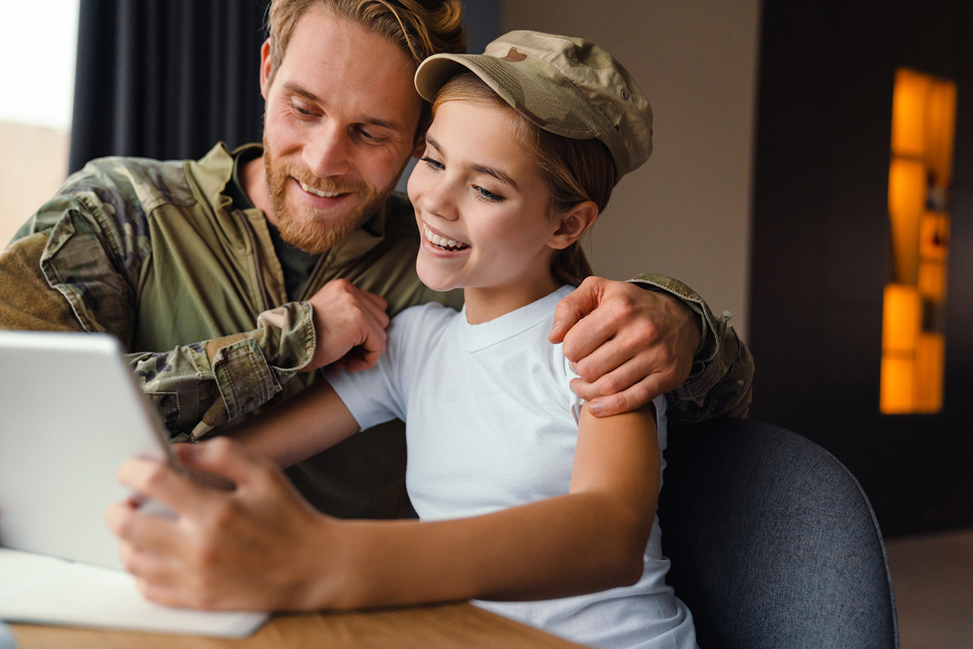 happy military man using tablet computer with her daughter