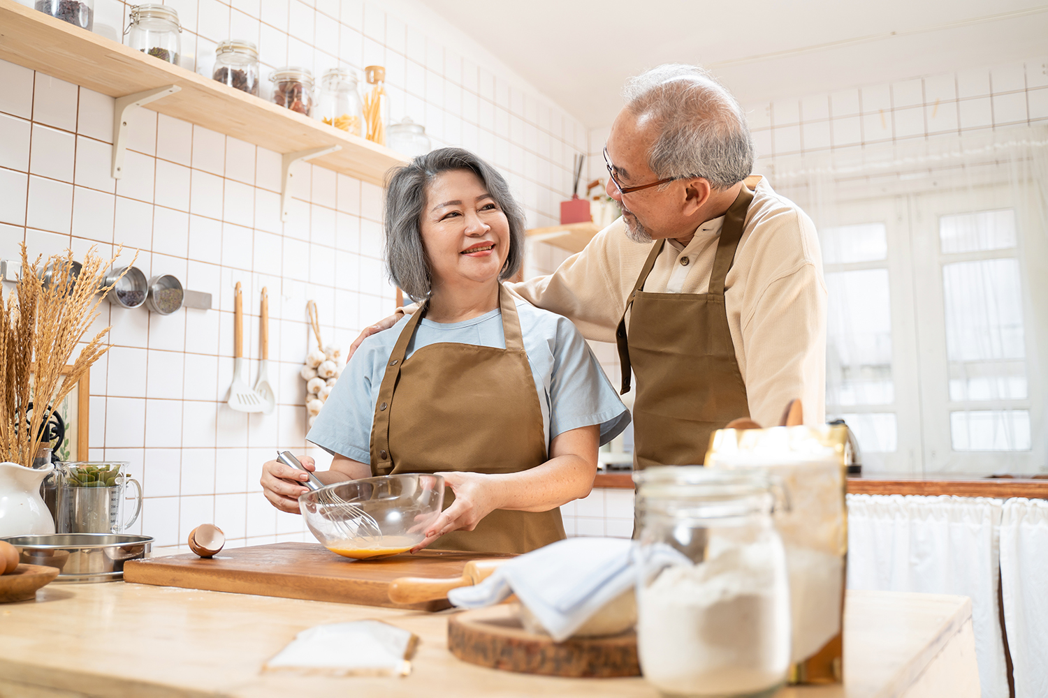 asian senior couple in kitchen cooking together